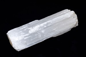 selenite log on black fabric background