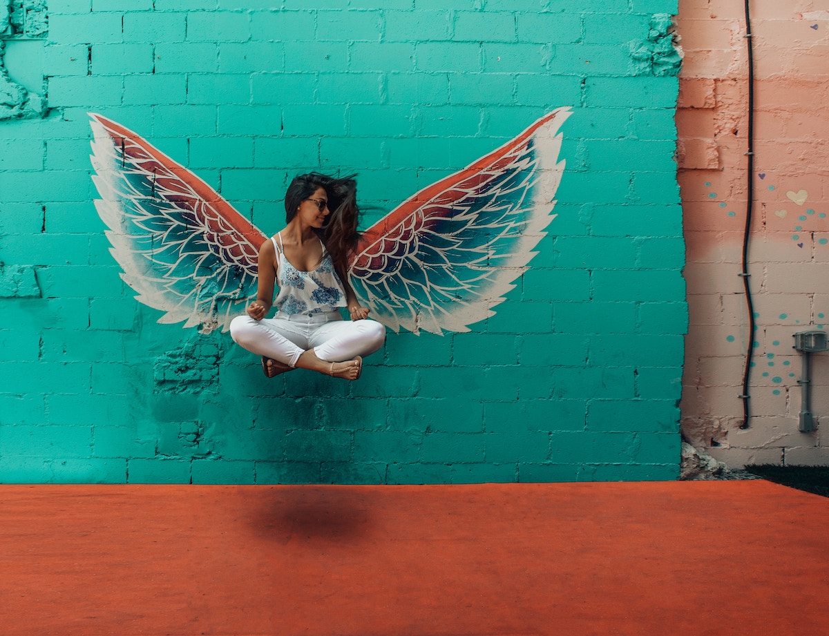 raise your vibration angel wings on wall